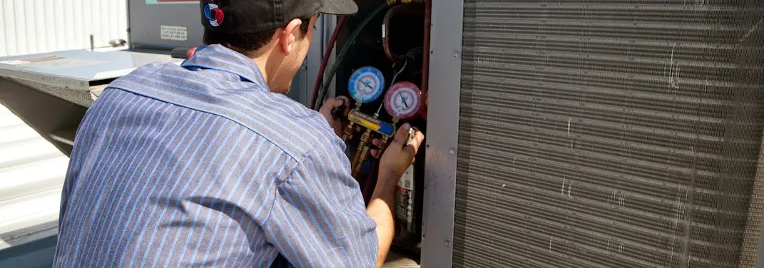 HVAC technician servicing a condenser unit in Picture Rocks